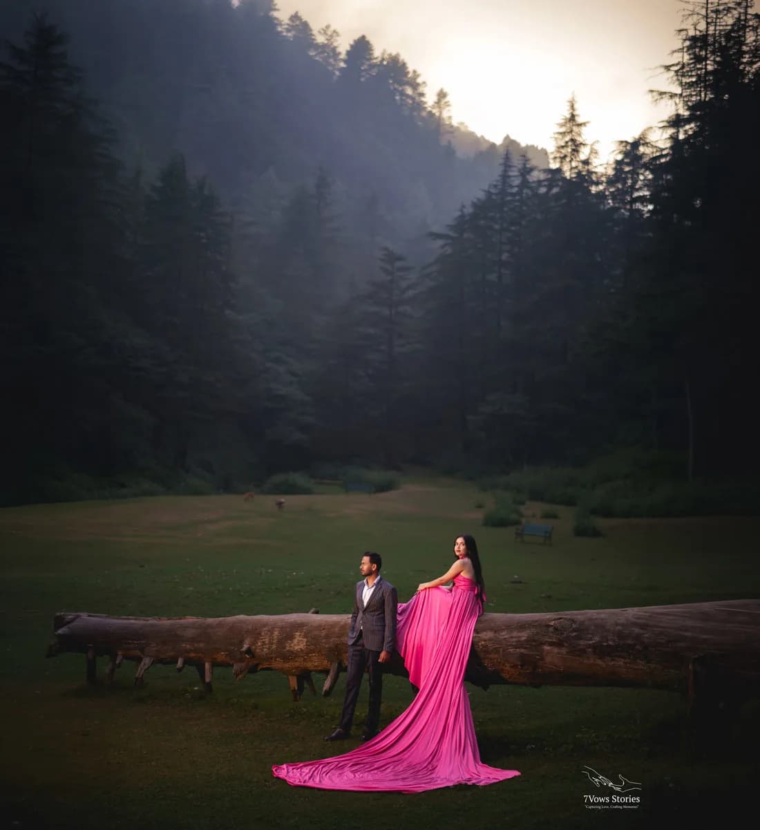 Couple in garlands beneath a shower of rose petals at the varmala