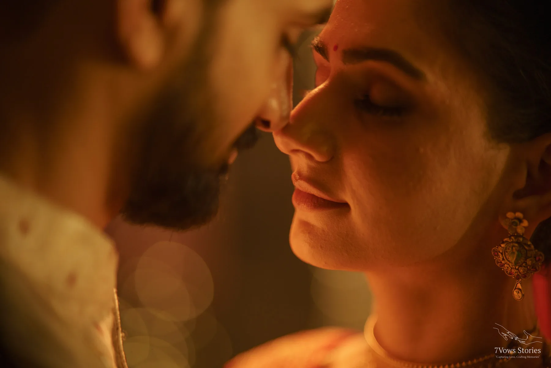Bride wiping away a tear beneath falling marigold petals at her haldi